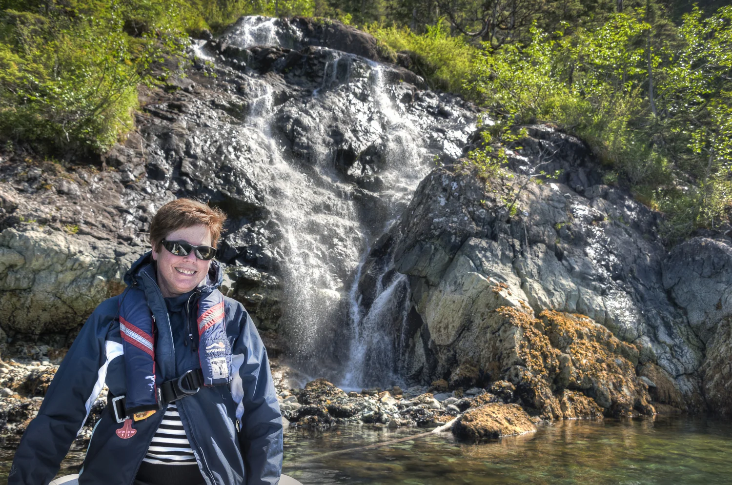 Karen checks out one on the many streams &waterfalls in Cooper Bay