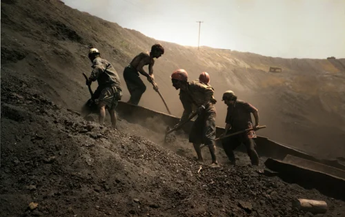 Beb C. Reynol; Workers shovel coal dust Karkar, Afghanistan