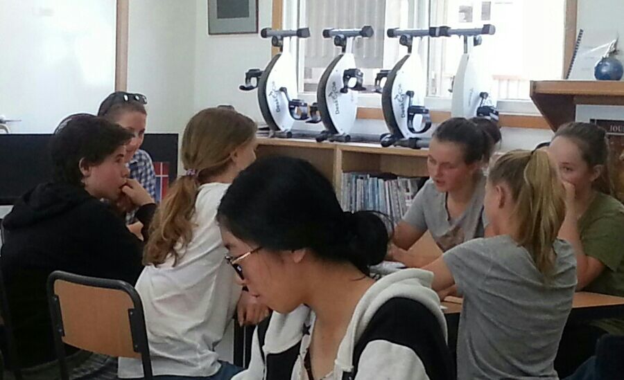 The Cooperative team prepares their debate. A member of the audience also researches her stance on the topic.