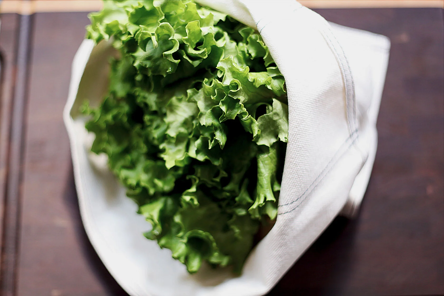 SPIN OR TOWEL-DRY YOUR GREENS THOROUGHLY AND PLACE THEM INSIDE, PRESSING OUT ANY ADDITIONAL AIR. STORE IN THE CRISPER DRAWER OF YOUR REFRIGERATOR.