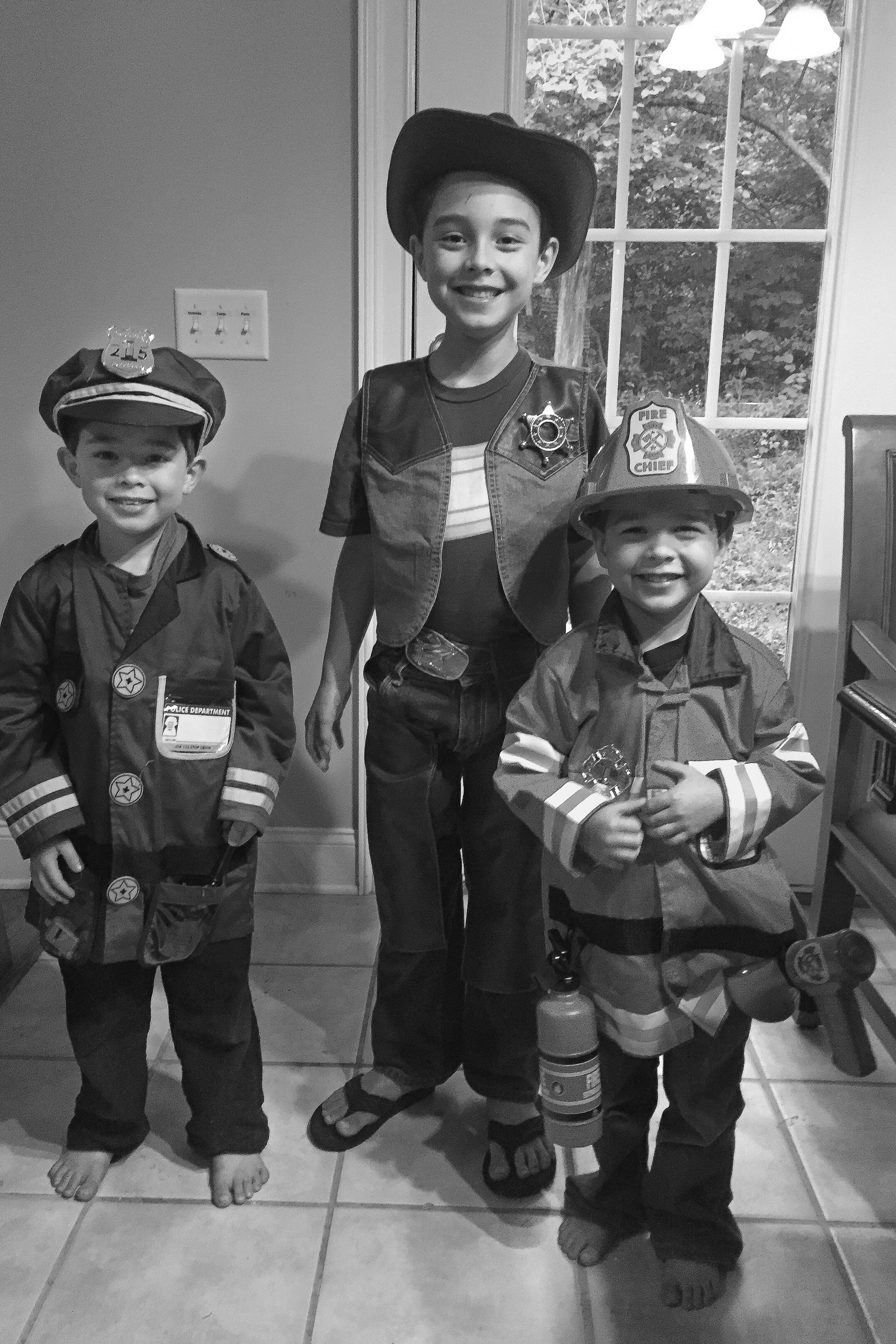 2015 - Noah (5), Abraham (7), and Daniel (3) are excited to use the new fireman, police, and cowboy outfits they bought with their own chore money.