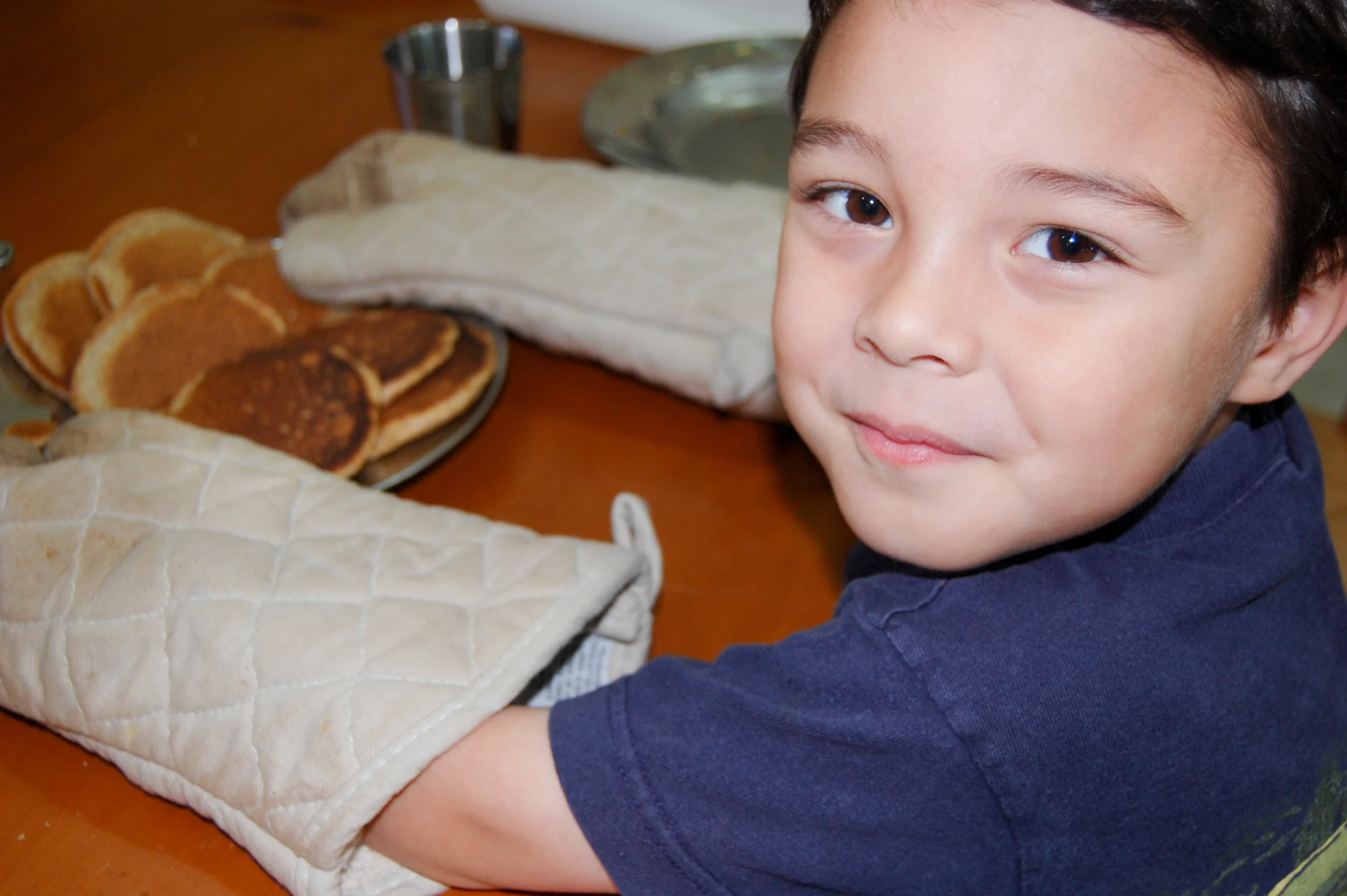 2012 - Abraham (4) serves homemade organic pancakes from the flour we milled with our mill. I believe I had him help me flip the miniature pancakes in our cast iron skillets.