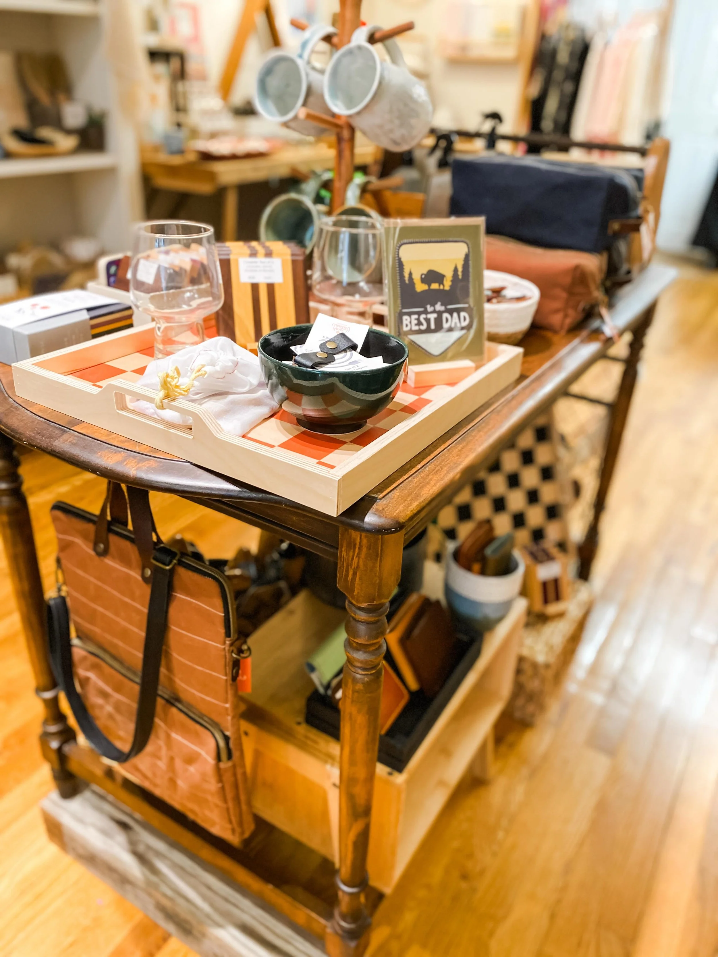 This table has been restyled ✨👏 Now featuring our selection of gift ideas for Father&rsquo;s Day

- Candles with &ldquo;manly&rdquo; smells
- Wood coasters to hold the perfect cocktail 
- A handy and stylish umbrella ☂️ 🦆 
- A rugged waxed canvas t