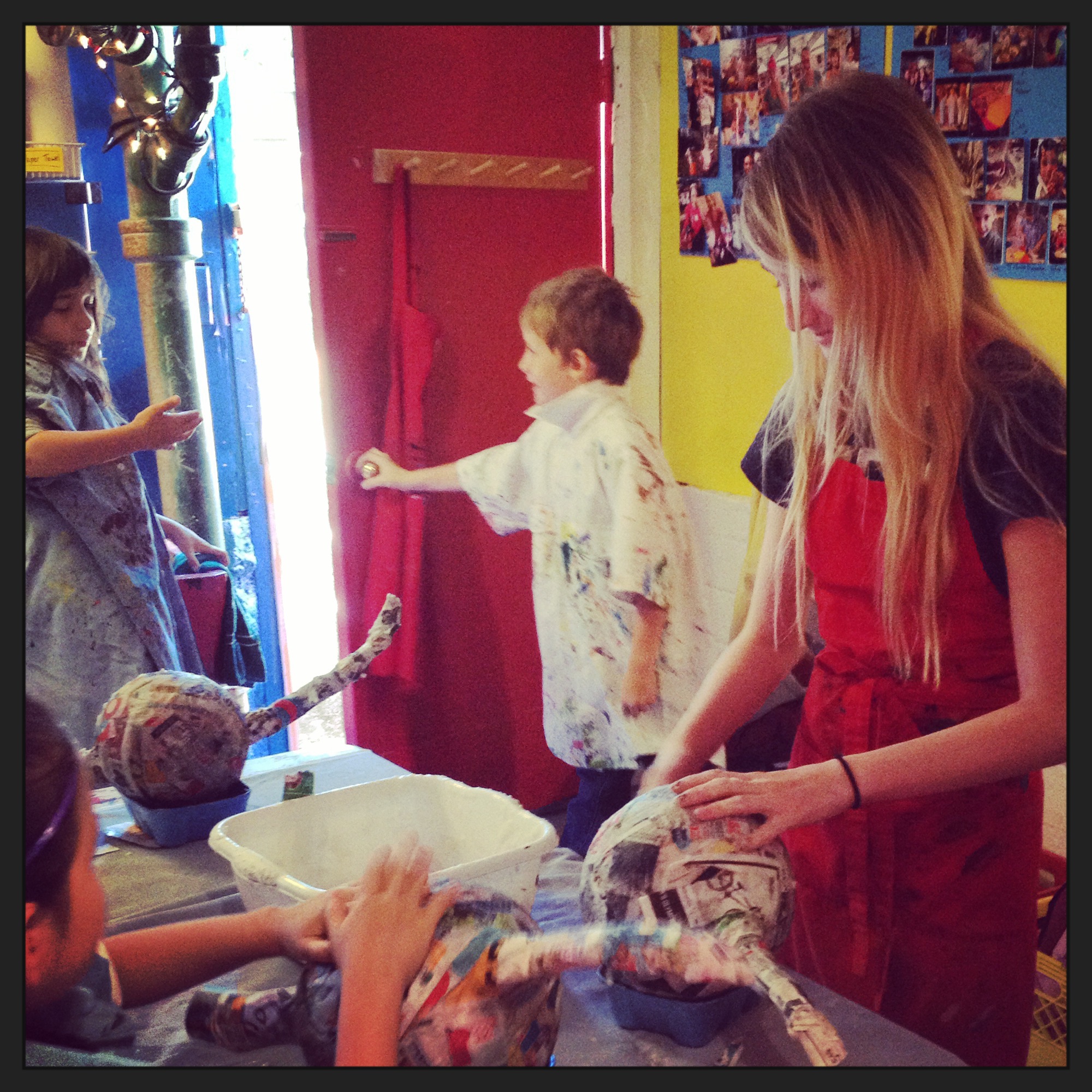 Shayden doing the final touches on a tired artist's paper maché dragon at a camp.