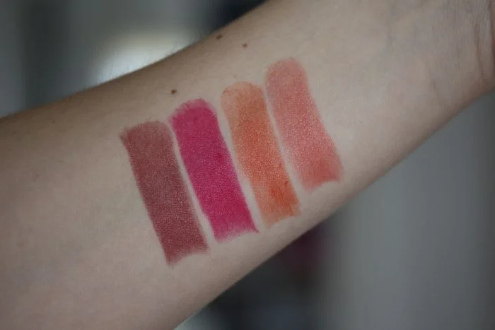 True Dimensions Lipstick swatches from left to right in Berry A La Mode, Sassy Fuchsia, Citrus Flirt and Tangerine Pop