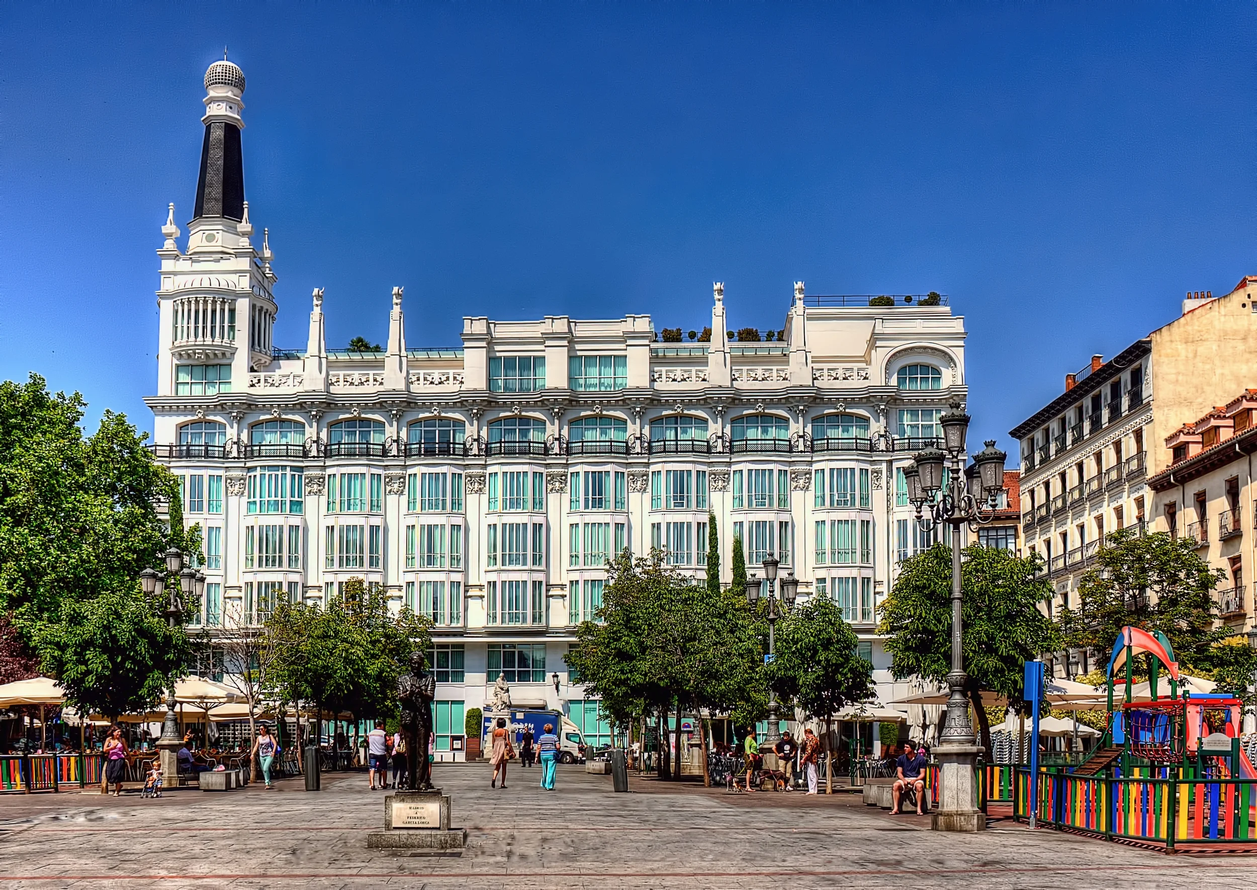 PLAZA FEDERICO LLORCA. CON LA ESTATUA . ME FASCINO EL CONTRASTE DEL HOTEL Y SUS VENTANALES CON EL CIELO. AZUL BLANCO Y AQUA
