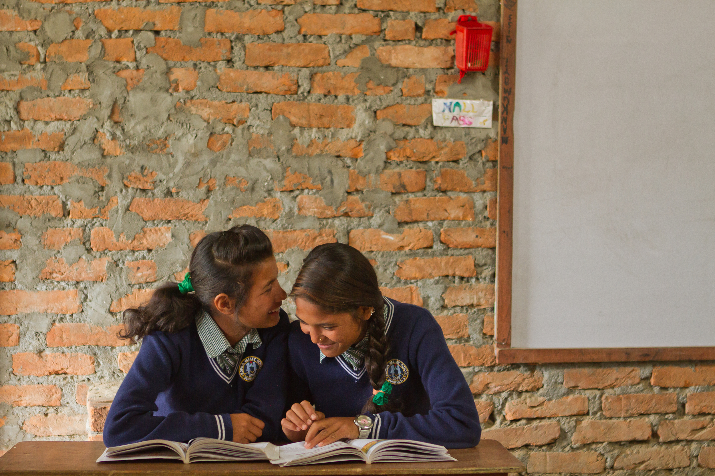  She's the First Scholars Kamala S. and Shanti S. whisper to one another at school in Nepal, March 2015. (photo by Kate Lord) 