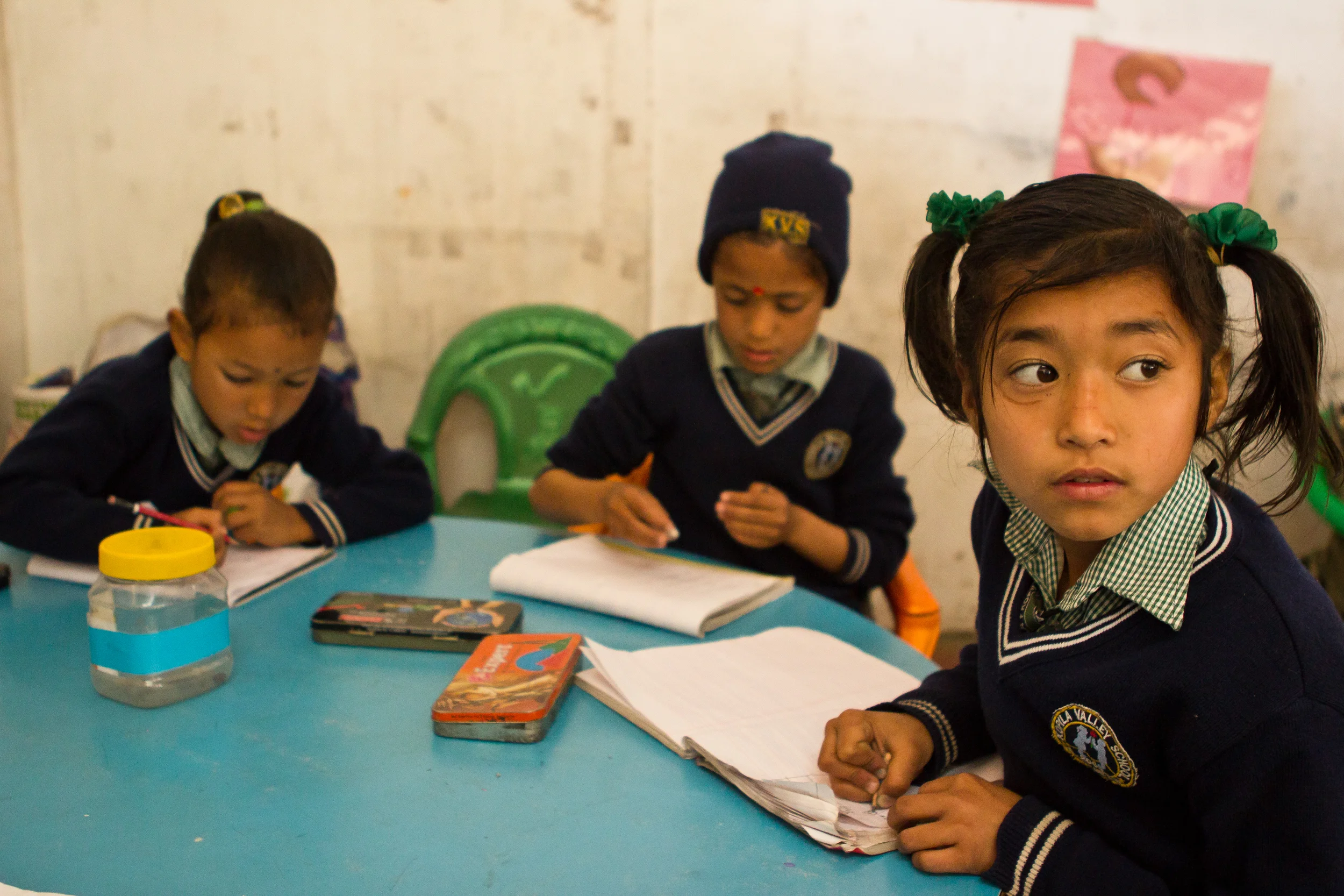  First grader Pushpa, right, copies from the board in class. 