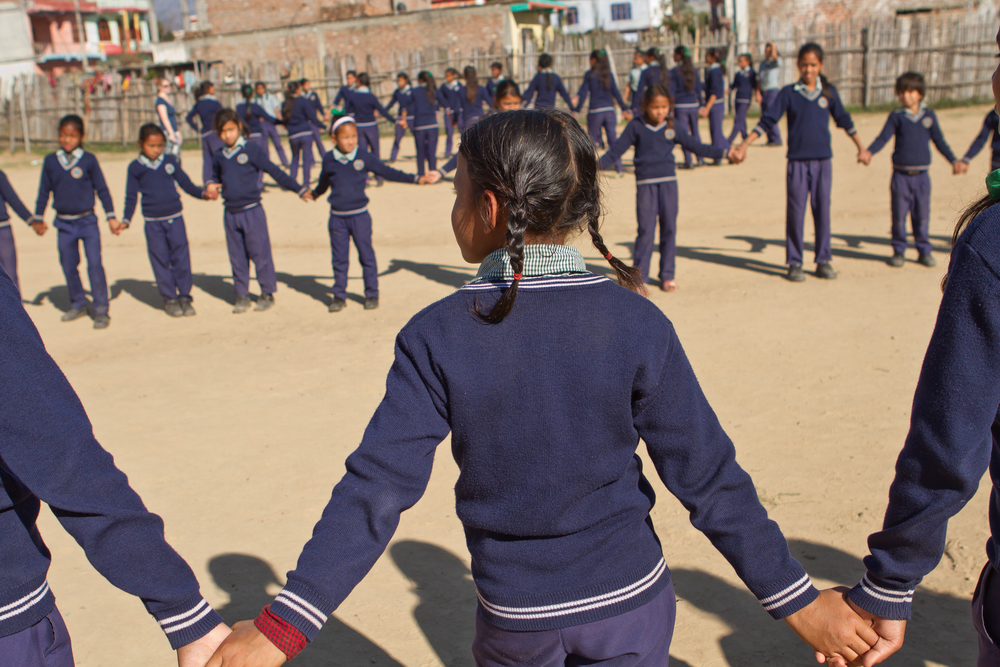  She's the First Scholar Asmita S. holds hands during a game of Red Rover in Nepal, March 2015. (photo by Kate Lord) 