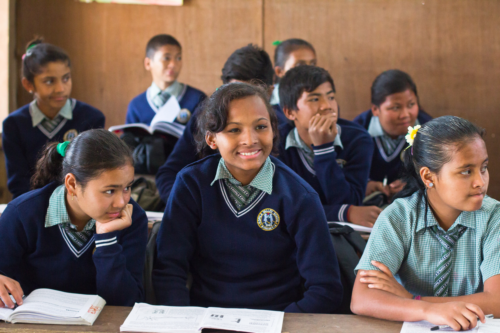  She's the First Scholar Sirjana S., center, listens during her  eighth grade class in Nepal, March 2015. (photo by Kate Lord) 