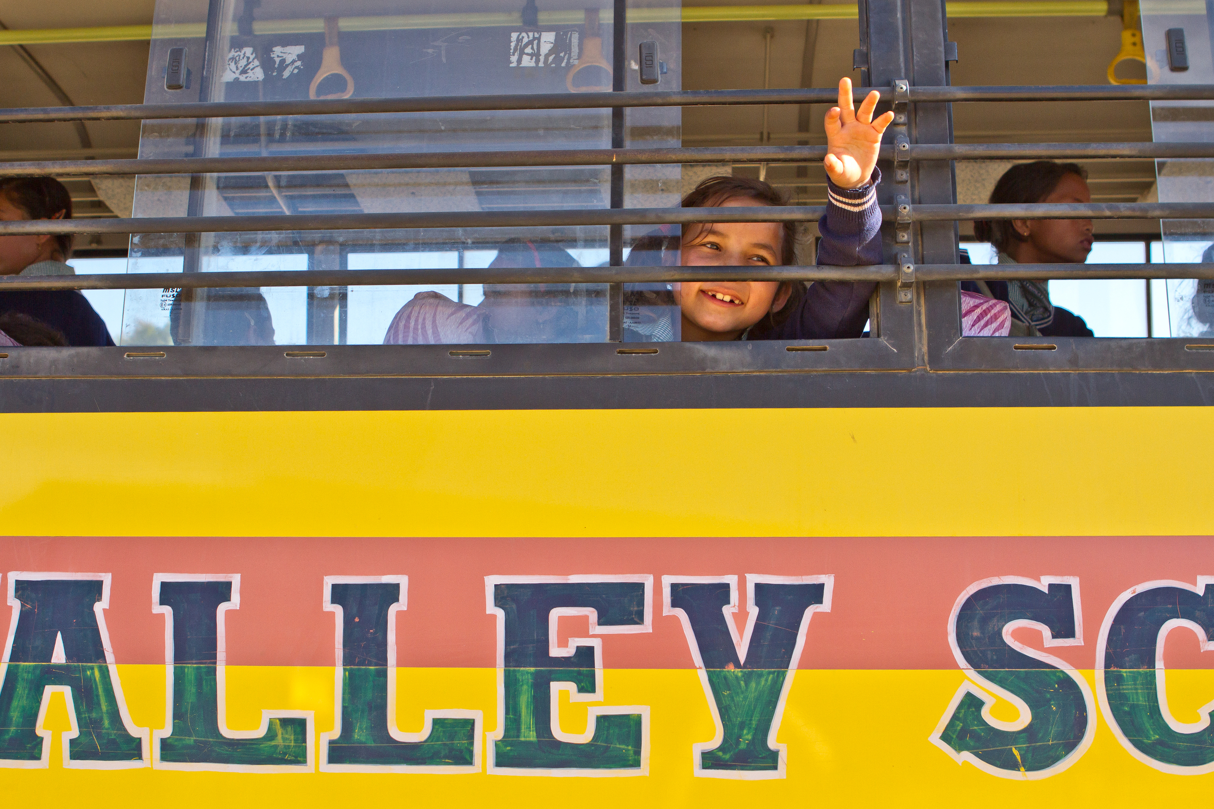  She's the First Scholar Jenisha S. waves from the Kopila Valley school bus in Nepal, March 2015. (photo by Kate Lord) 