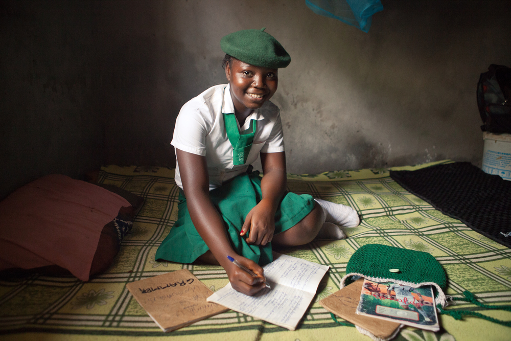  Mariama, 14, does homework in her room. She's the oldest sibling and helps her younger brother and sister with their schoolwork. 