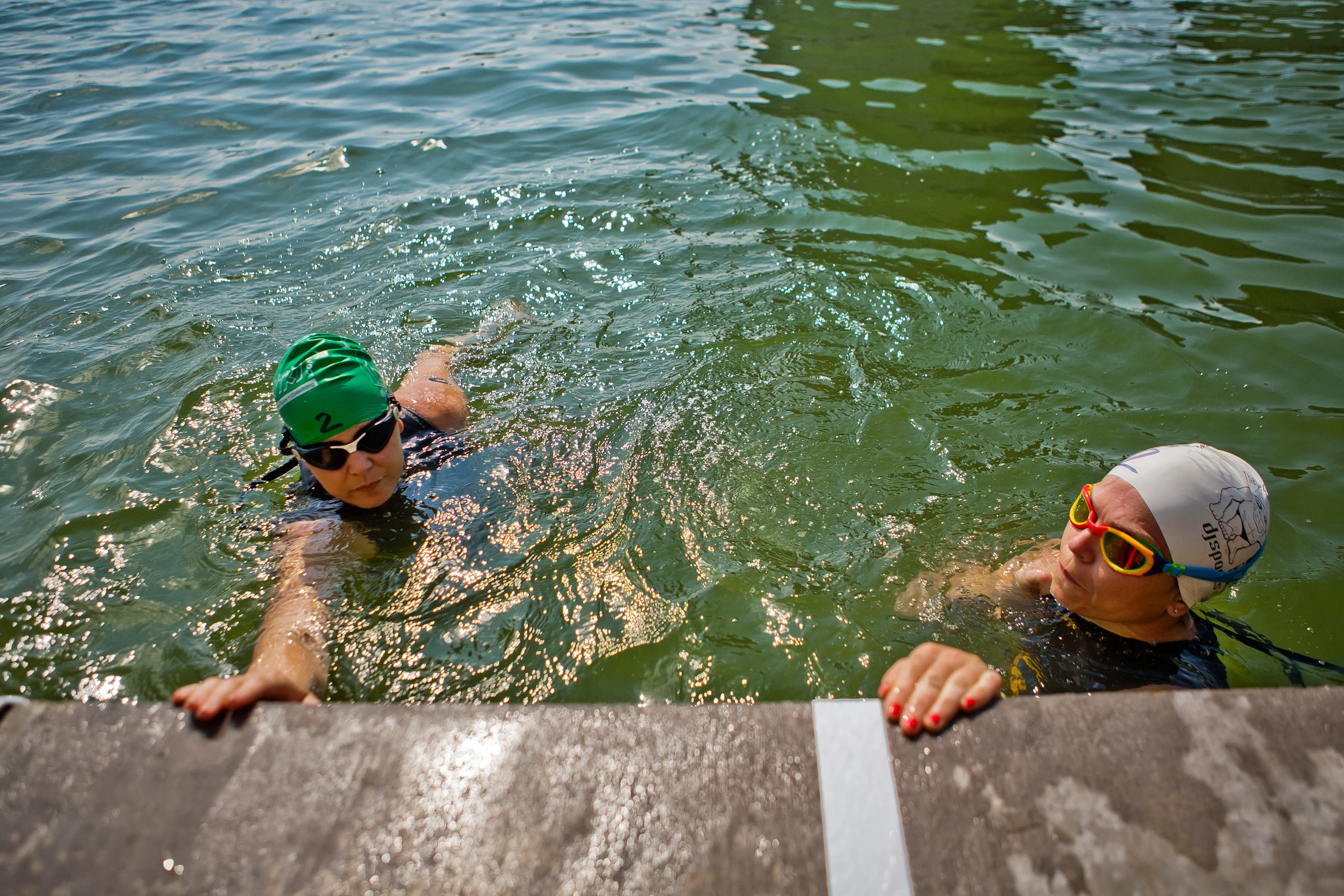  Amy Dixon (left, in green cap), a visually impaired sommelier and triathlete, and her guide Caroline Gaynor, co-triathlon director at Team Red, White & Blue, prepare to begin the swim portion of the 2014 Dallas Panamerican Triathlon Confederation (P