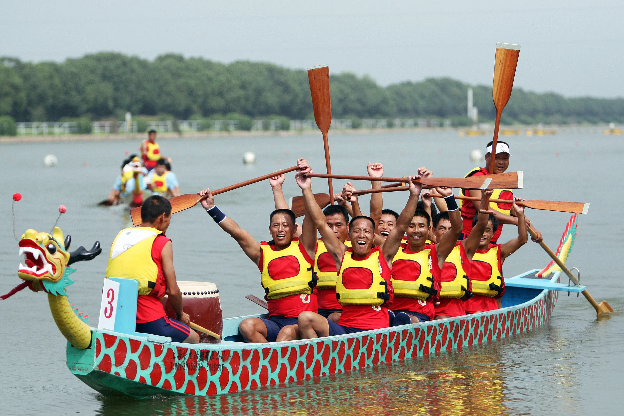 Members of China Team 2 celebrate their victory in the 250 meter dragon boat final race at Shanghai Aquatic Sports Center. 