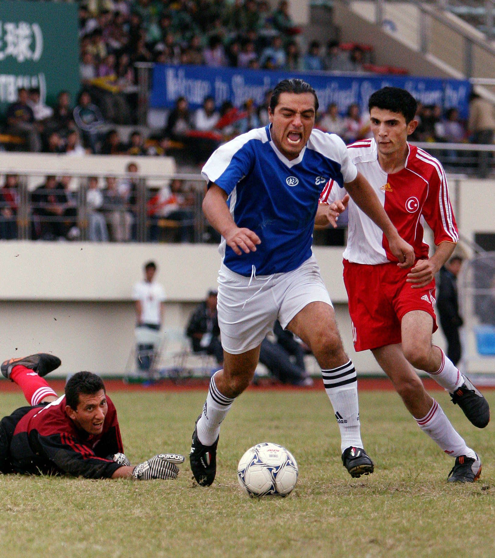 Gustavo Deras of El Salvador rushes past Turkey’s Ismail Sari and Ozgur and Ozgur Tas in a match-up during the 2007 Special Olympic World Summer Games at Shanghai International Studies University Stadium. El Salvador won the match. 