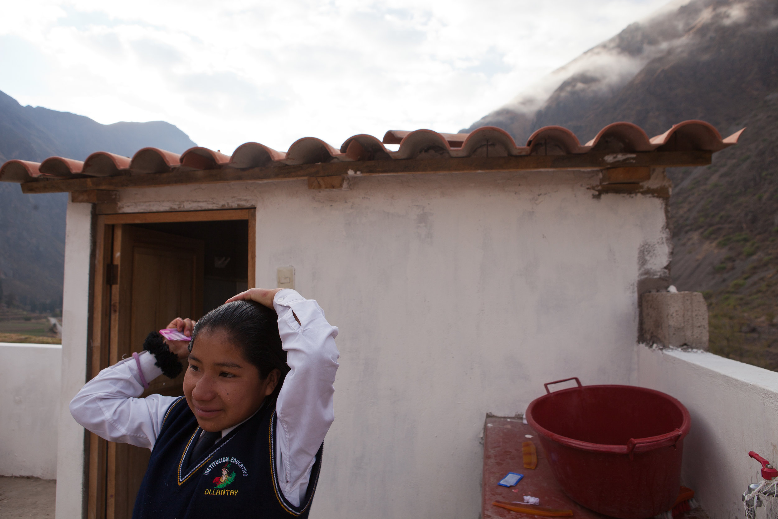  5:30am: Elizabeth wakes up and starts her day. Here, she combs her hair outside the dormitory's upstairs bathroom. The fifteen girls manage to split two bathrooms among all of them! All of the girls' basic needs are supplied by the Sacred Valley Pro