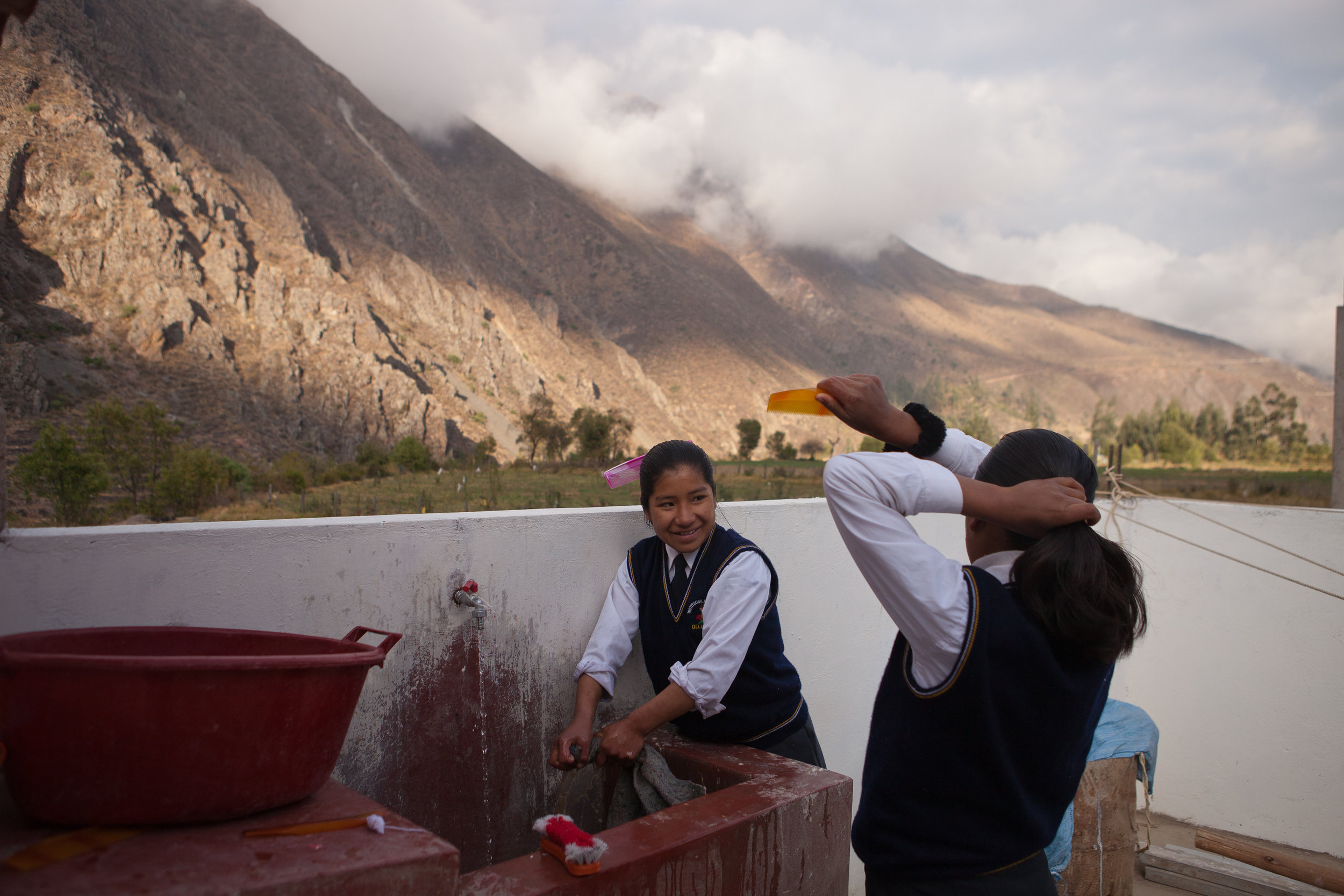  7am: Elizabeth washes the dish towels from her morning chores on the rooftop of the dormitory. The dorm is nestled in the Andean highlands.
 