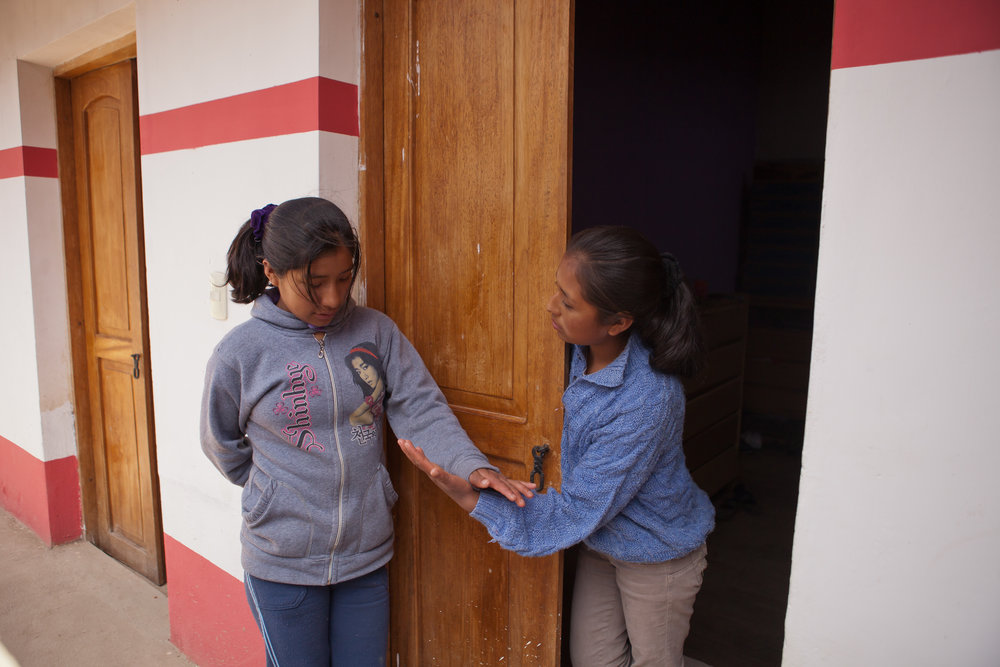  4pm: Back home at the dorm, Elizabeth chats with her friend Mariela. The girls come from villages all over the area to live in the Sacred Valley Project dorm and attend school in Ollantaytambo. 