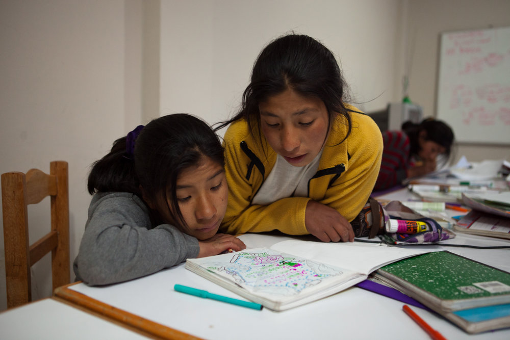  Elizabeth and Nilda look over notes from the day's classes during homework time. 15 girls live in the dorm together and are all in secondary school - the older girls often help the younger girls with their studies.  