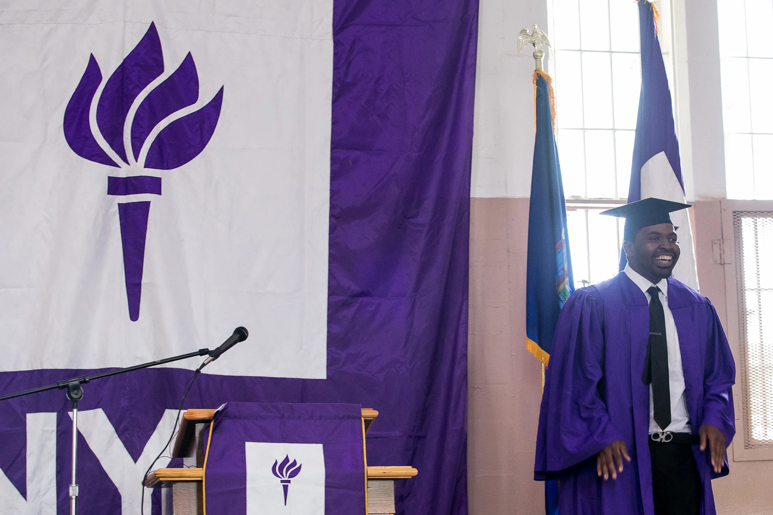 Vincent shows off his suit under his graduation gown. He has been released from Wallkill but came back for graduation, which he said was difficult, but he was glad that he did. He's working with program staff to continue his education at NYU's main campus.