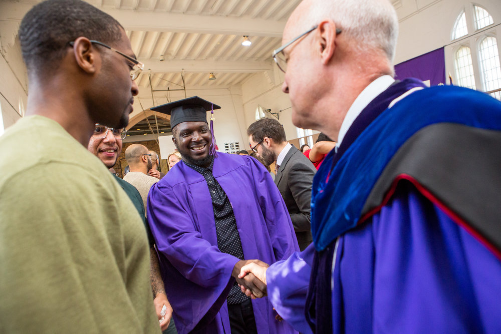  Graduate Ryan Burrell shakes hands with New York University President Andrew Hamilton after the ceremony. 