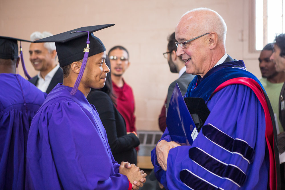  Graduate Khalan Pendelton meets NYU President Andrew Hamilton. The program offers credit-bearing courses and educational programming. 