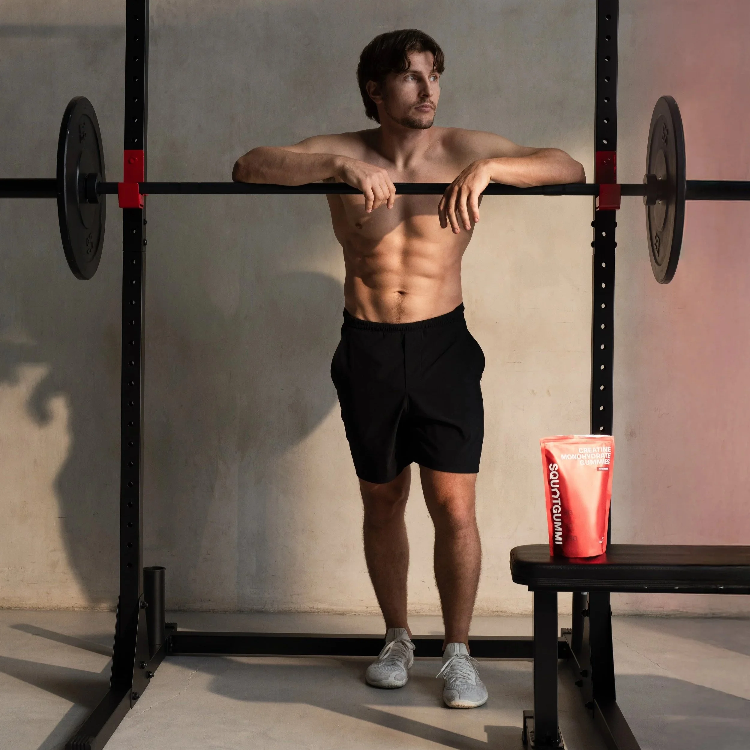 Erik Rokisky strength coach standing in squat rack with SquatGummi supplement