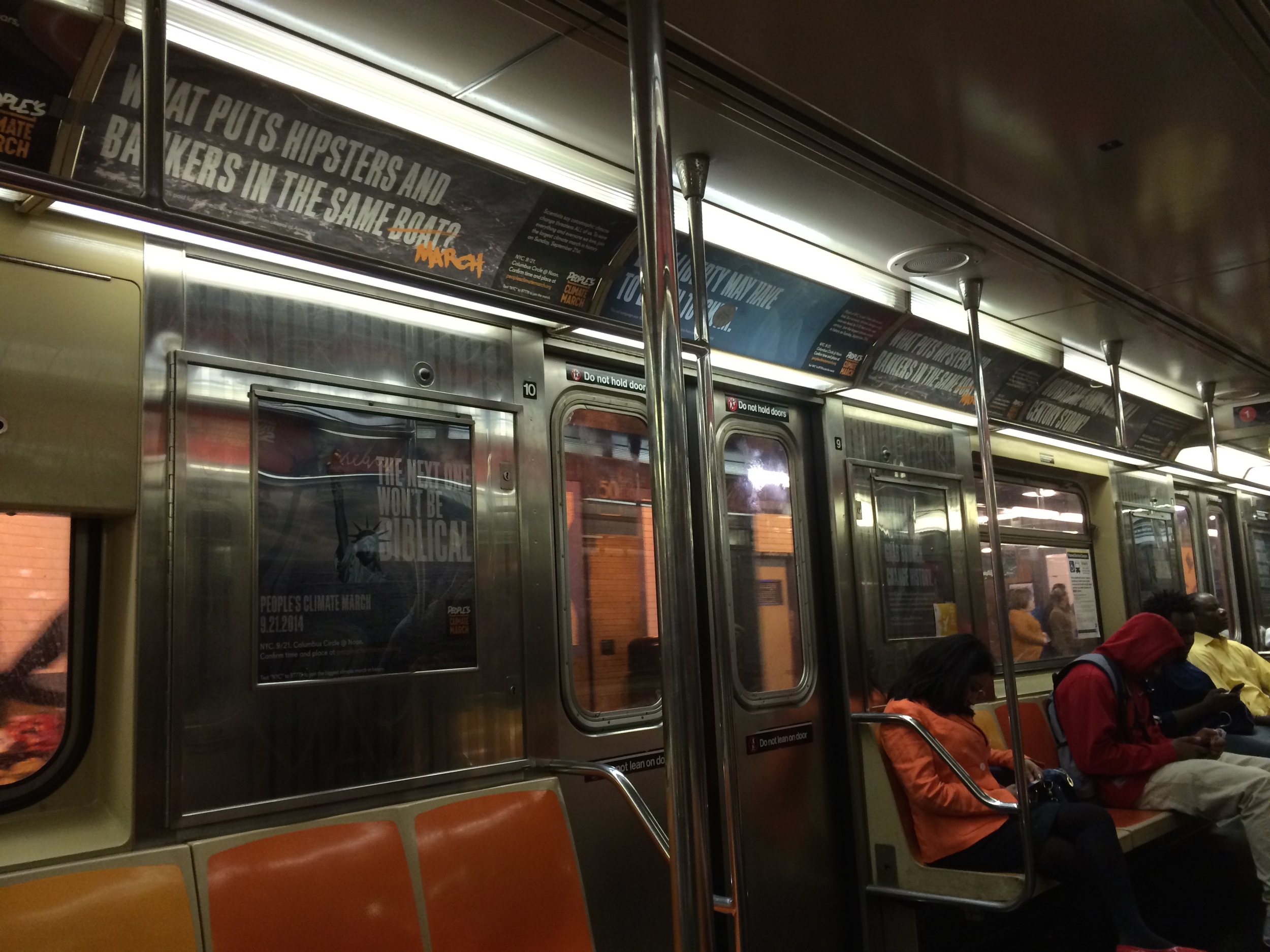 NYC Subway car, covered in signs encouraging people to attend the march