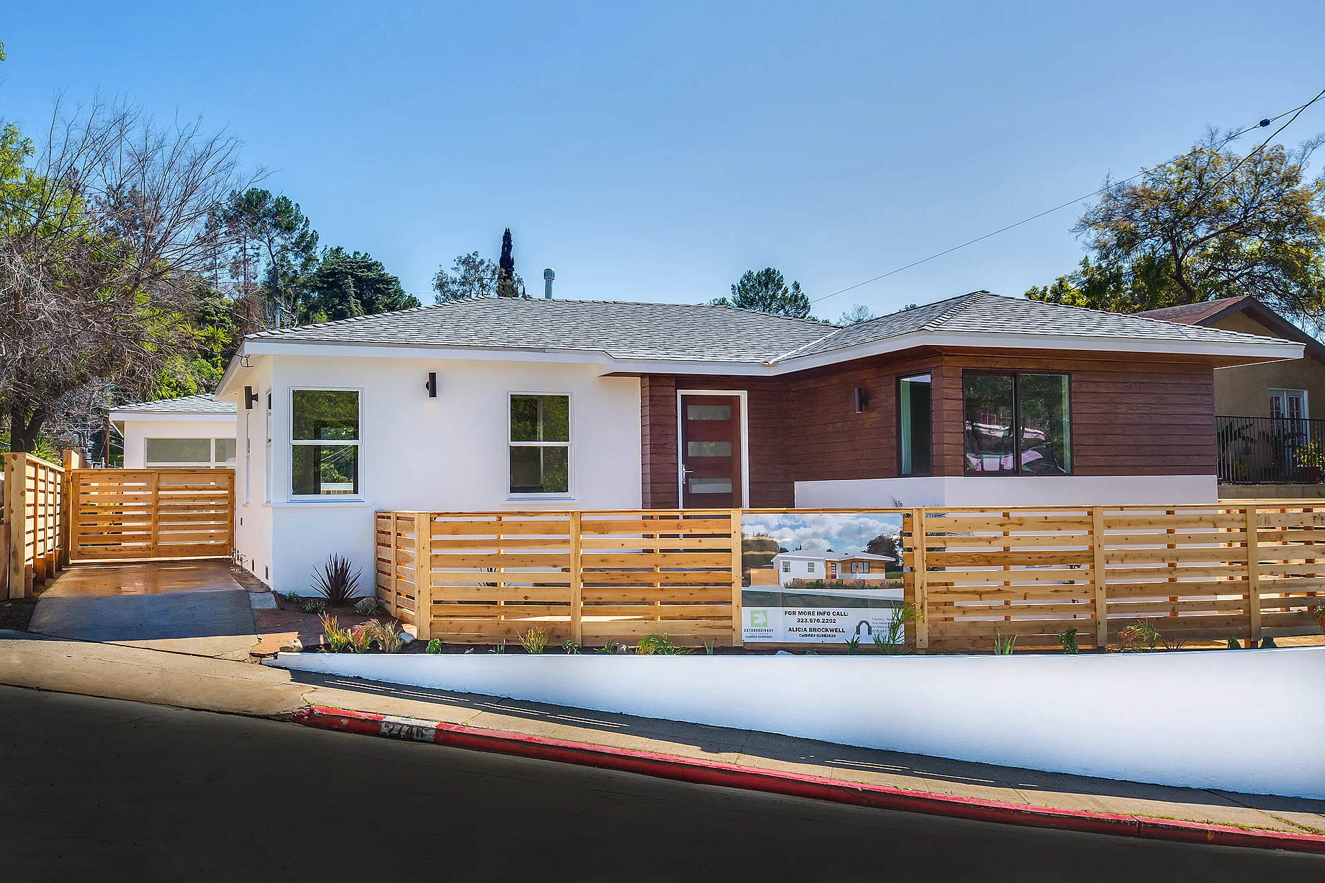 The completely fenced in property includes a separate entry gate and driveway gate for maximum privacy. The clean white stucco exterior walls are complimented with rich wood siding, as you walk along the flagstone path to the modern wood front door. 