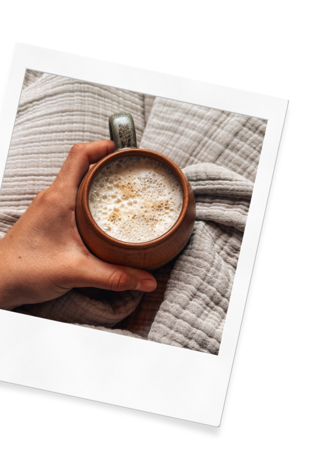 A hand holding a latte on the Wildflower Doula Services website.