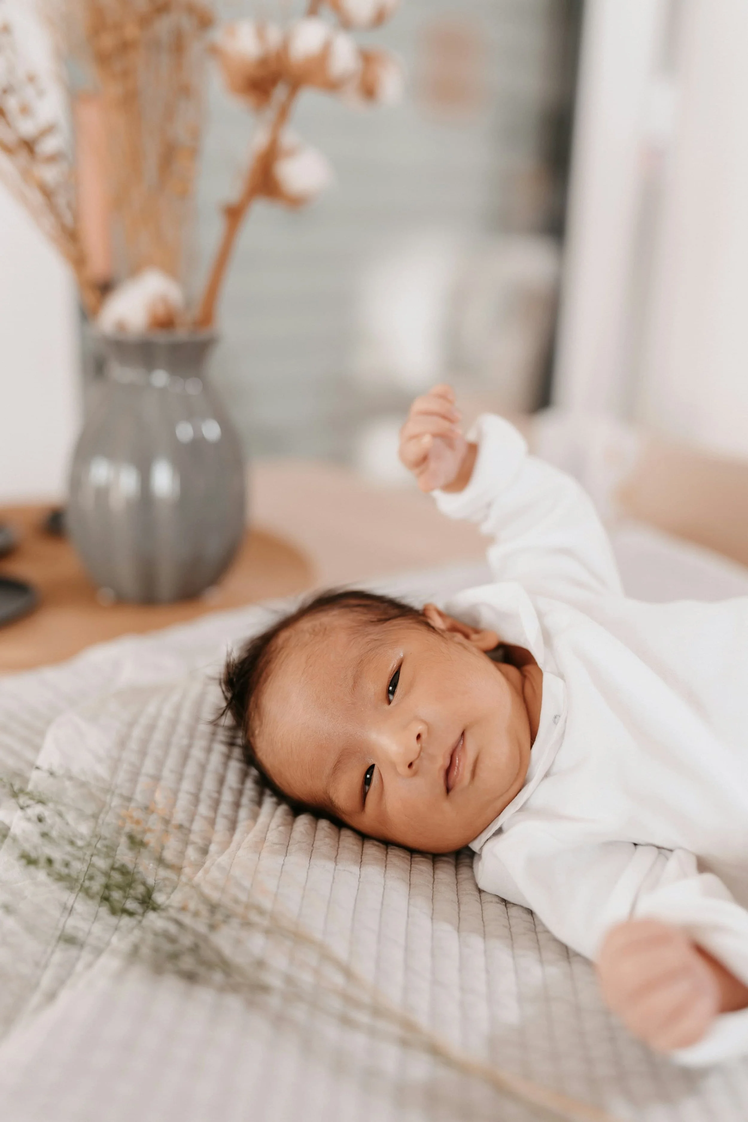 A baby receiving newborn care from Wildflower Doula Services smiles softly in Portland, Oregon.