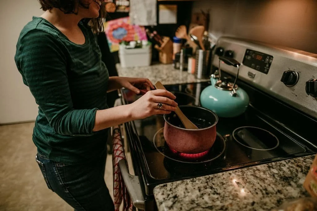 Julia-Rose Scianna cooks a meal for a postpartum mom as one of her services in her newborn care package in a Mt. Hood home.