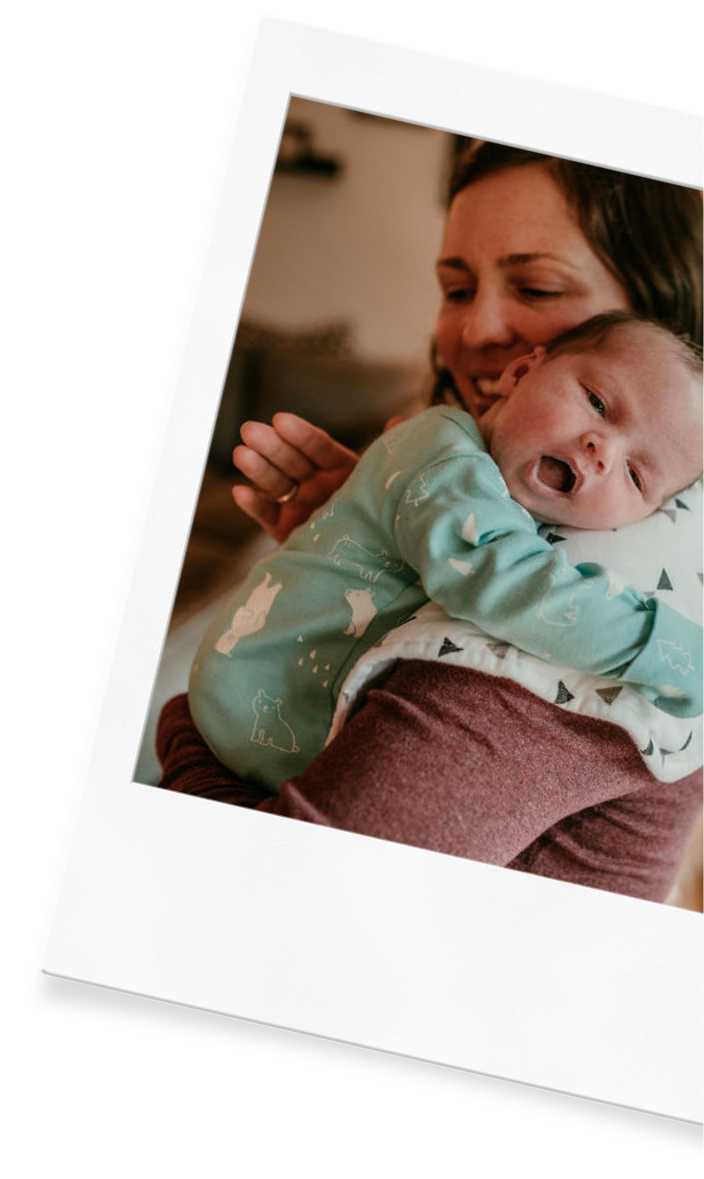 Julia-Rose Scianna holds a newborn while discussing sleep consulting services with parents in Gresham.