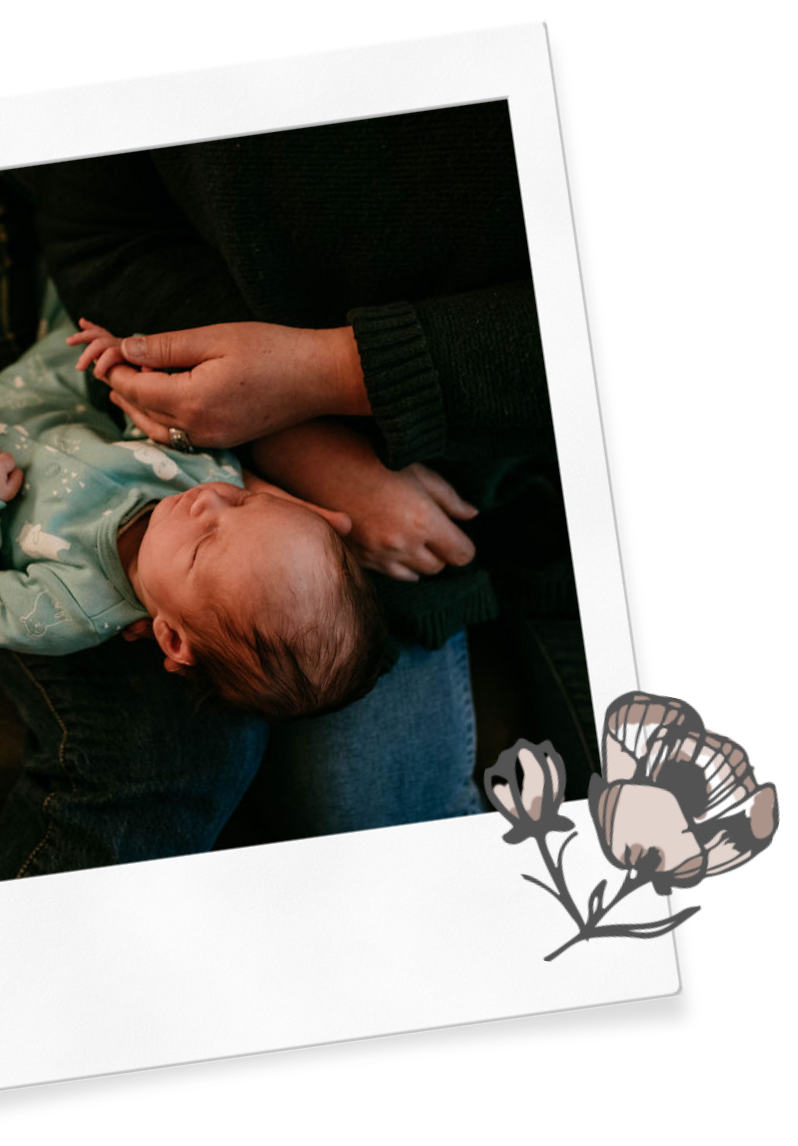 A sleep consultant with Wildflower Doula Services holds a baby's hand in Hood River.
