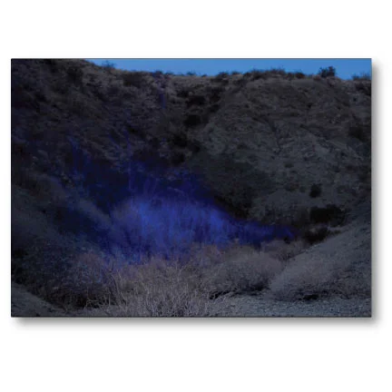 Postcard with digital download - Photo by Bridget Batch – The image is called Glow, San Andreas. It is part of an evolving series called Glow that features interventions performed for long camera exposures in locations marked by geologic instability. In this image, I am performing a 20 minute dance – while holding a light – over the San Andreas fault, near Desert Hot Springs, CA. The line I create traces the fault but also evokes earthquake lights, a strange and not entirely scientifically proven phenomenon of eerie glowing lights occurring during certain earthquakes.