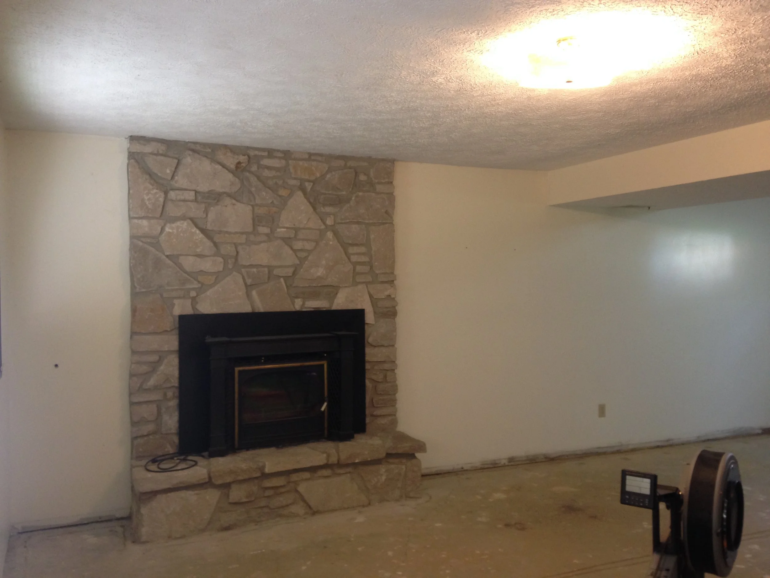  Before. Your standard lower-level, bi-level family room. Complete with the fireplace.&nbsp; 