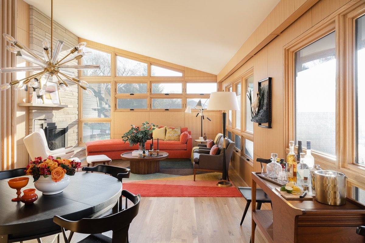 modern-great-room-orange-sectional-built-in-bar-wood-paneling-floor-to-ceiling-windows-indiana.jpg