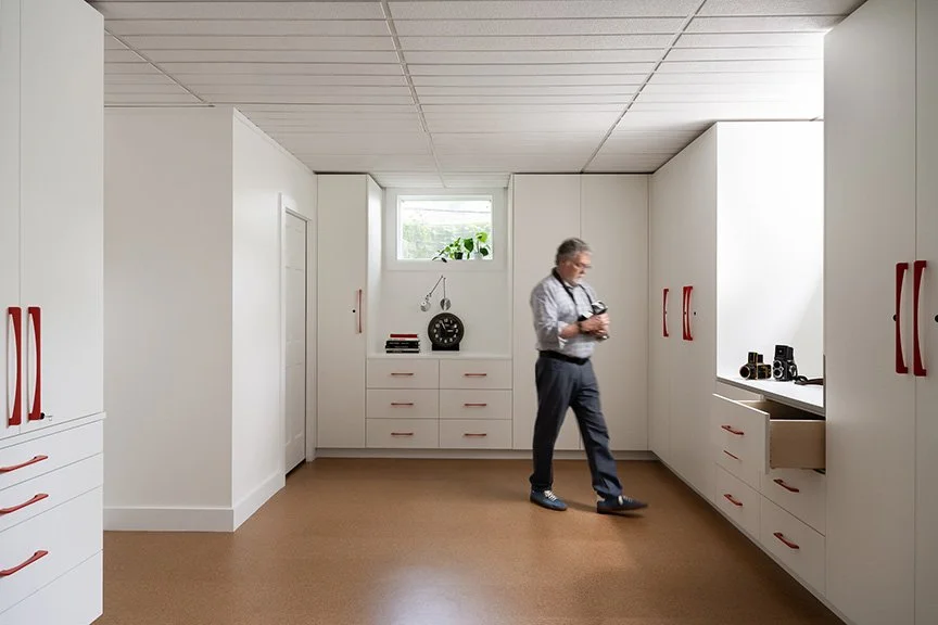 a-good-vintage-storage-custom-cabinetry-red-handles-with-clocks-cameras.jpg