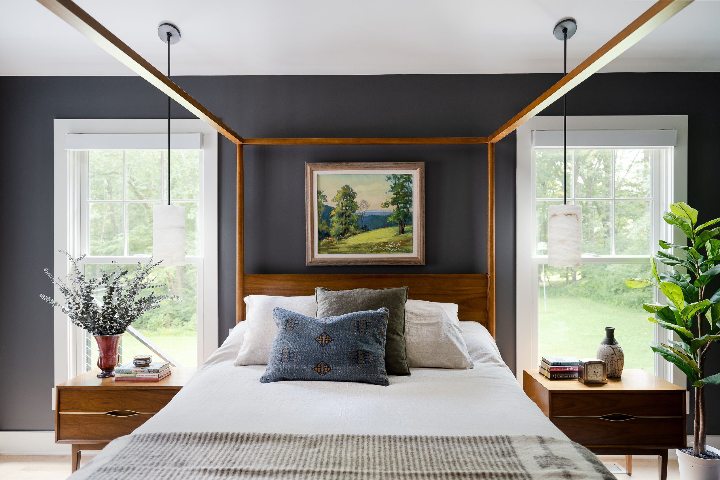 Modern bedroom design by Indianapolis interior designer featuring custom four-poster bed and dark accent wall