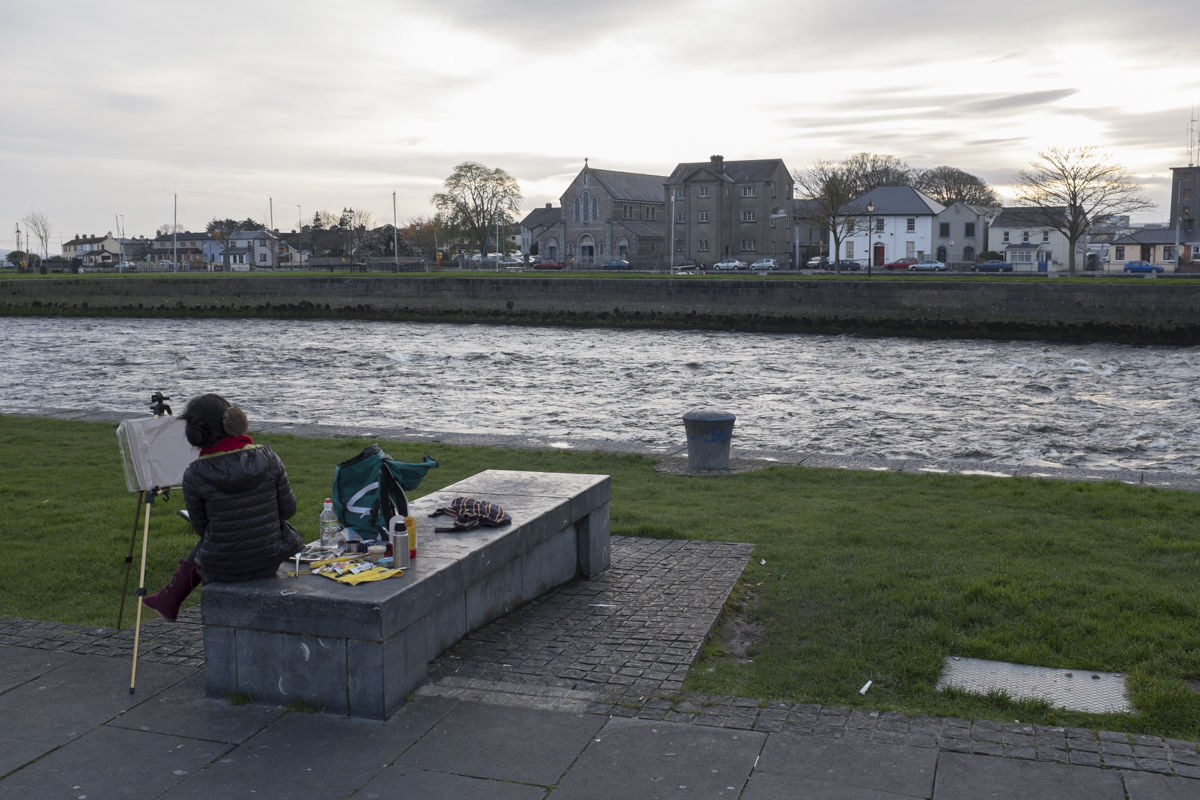 A girl painting by the riverside.