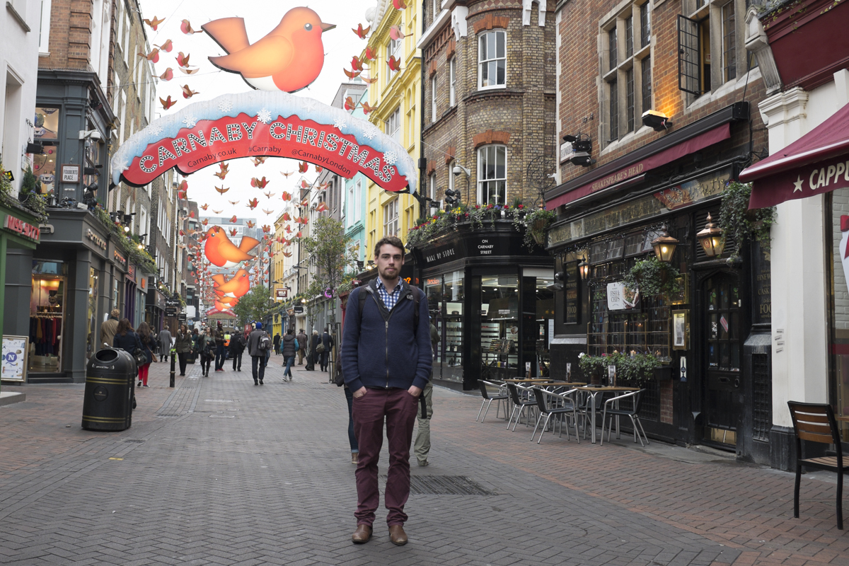 Will in front of a christmas bazaar.