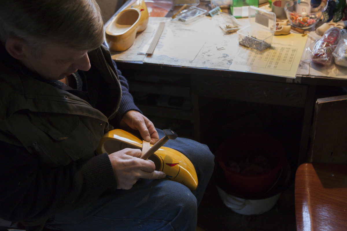 This guy is fitting a strap to the shoe - there are two styles. One that sort of covers the whole foot and this one which is a bit easier to wear and not as tight on the foot. The thing about the shoes is that they won't ever really break in - as their made of completely of wood.