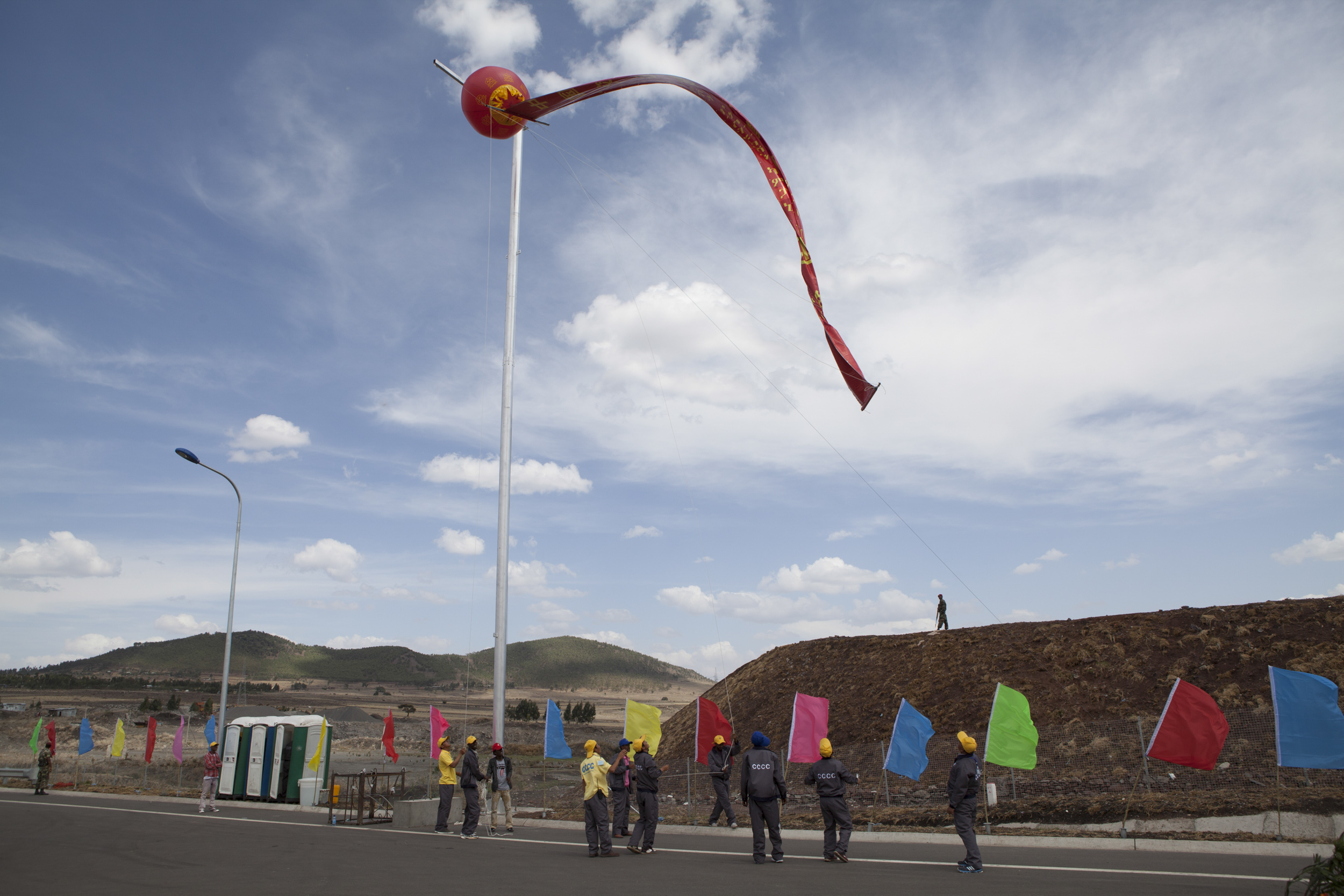   Ethiopian and Chinese workers of the China Communication Construction Company secure a flag at the site of the Addis Ababa-Adama toll road on May 5, 2014. The site was christened by Chinese Prime Minister Li Keqiang. Li arrived in Ethiopia for the 