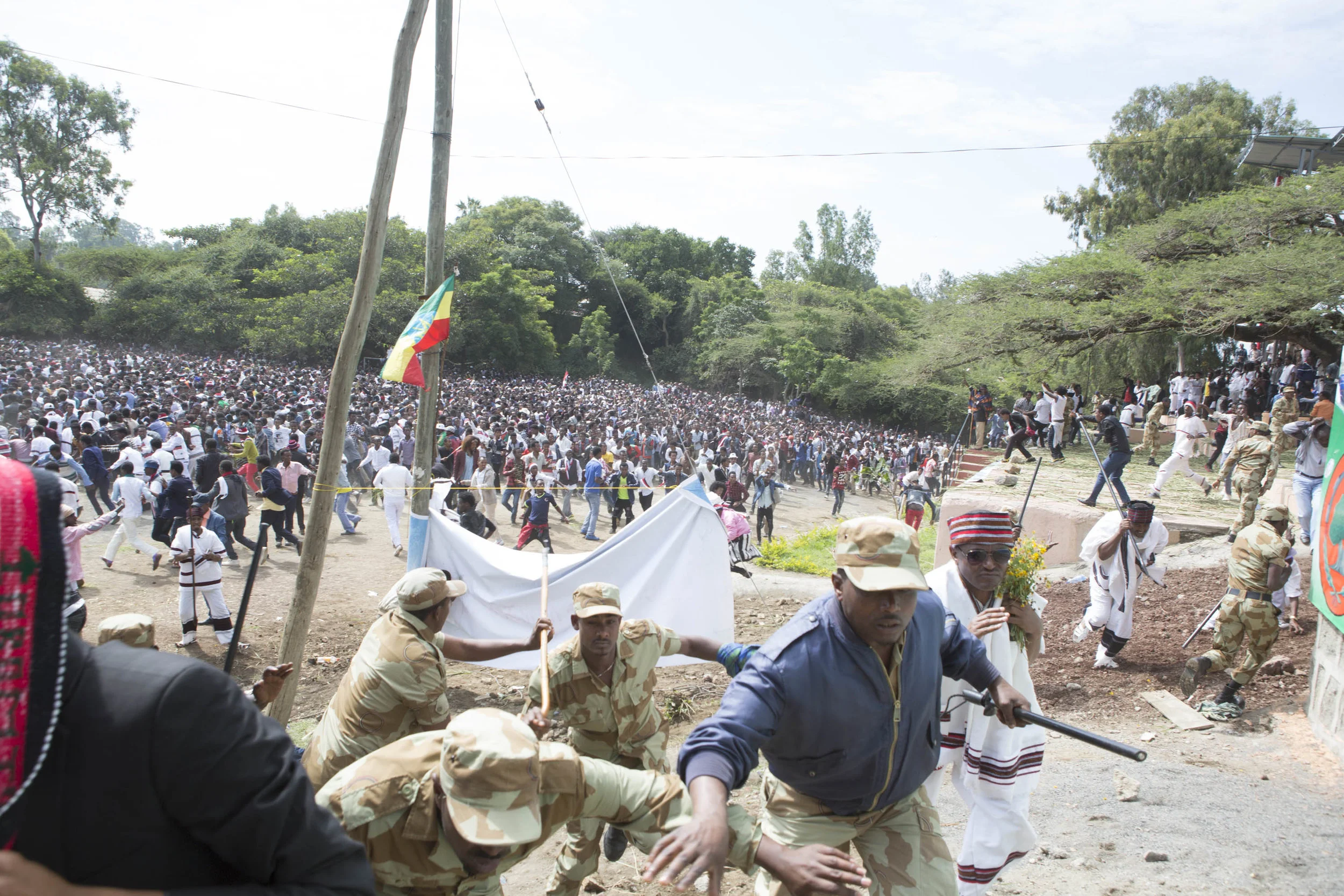 Police and onlookers flee after rocks are being thrown.
