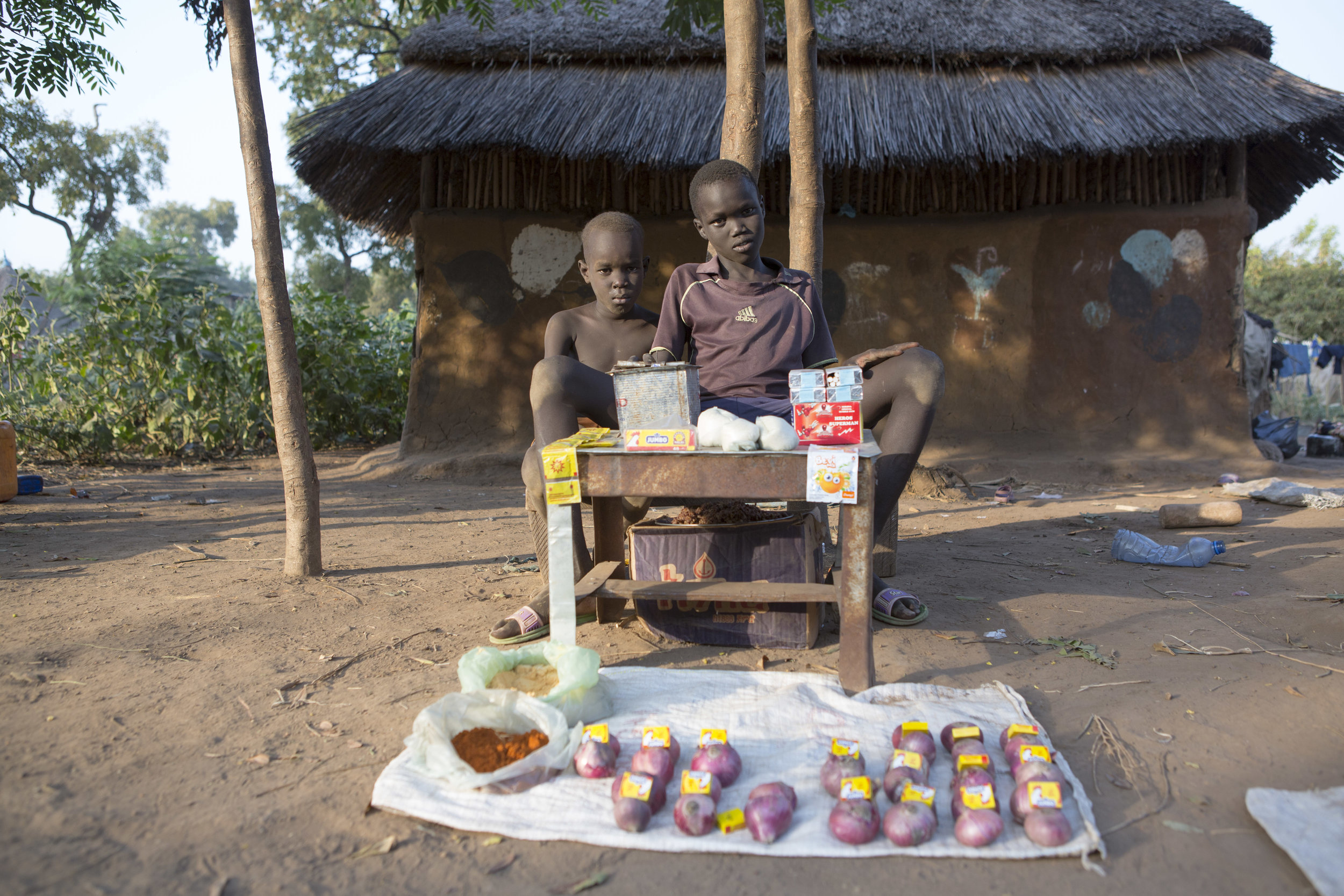  Two young boys sell goods outside of their family's home in the Kule Refugee camp for South Sudanese in the Gambella region of Ethiopia on 25 Nov 2017. MSF / Zacharias Abubeker 