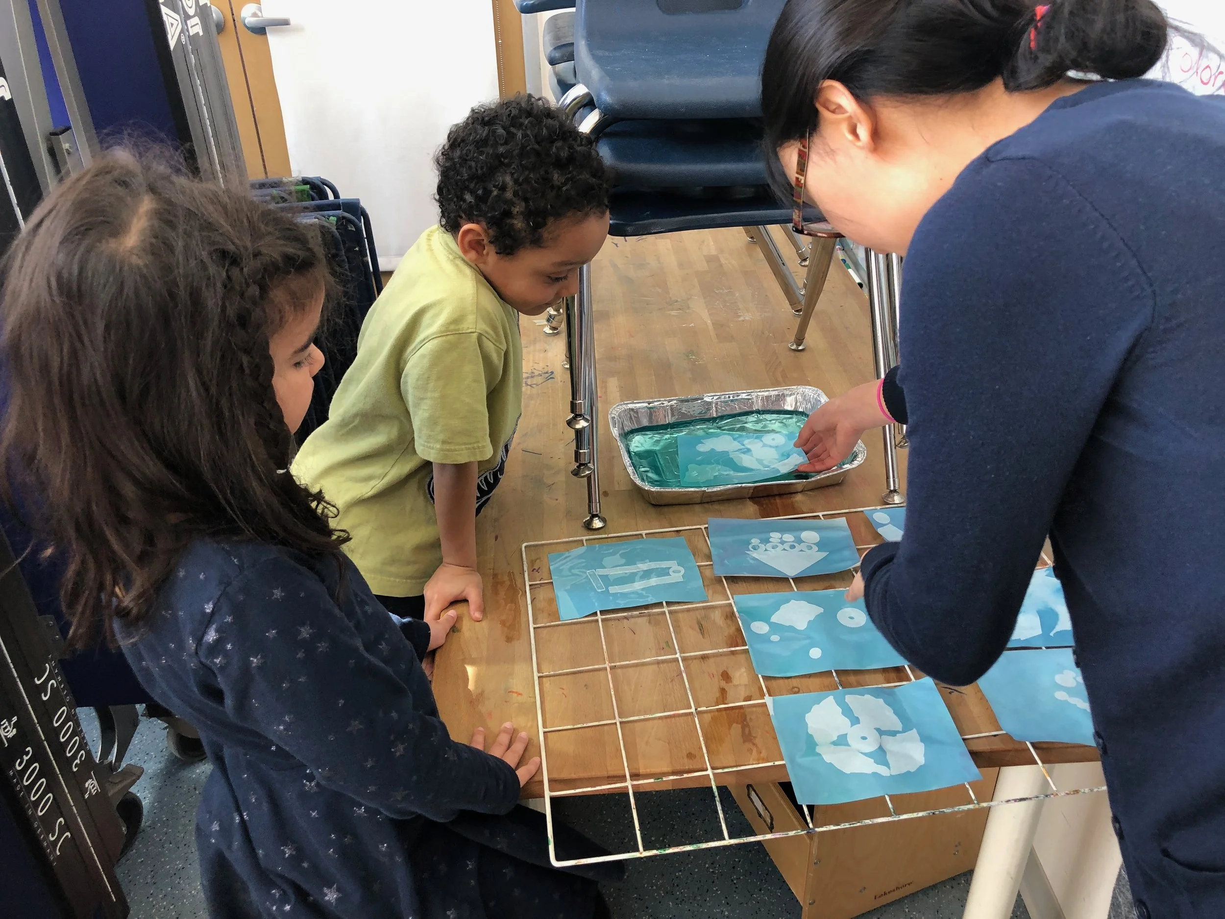 PreK students are making rayographs to study the sun and how shadows are made.