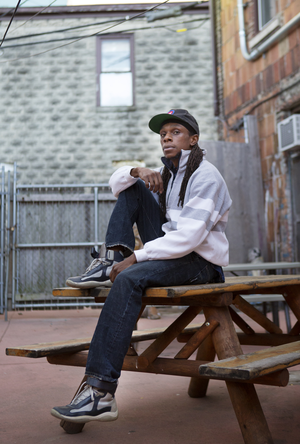 Bryce Anderson-Small, a former record executive, now devotes his time to youth media literacy with his company, Detroit Recordings. He also raps with Kadiri Sennefer, a farm manager at D-Town Farms. Here, Anderson-Small sits outside the Artist's Village, a space for performers to rehearse and convene.