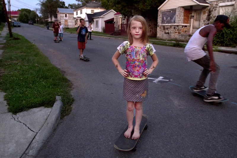  Sierra Wright, 7, stands on a skateboard to pose for a portrait as other neighborhood kids continue to skate down Campbell Avenue South East at 17th Street on August 6, 2012. 
