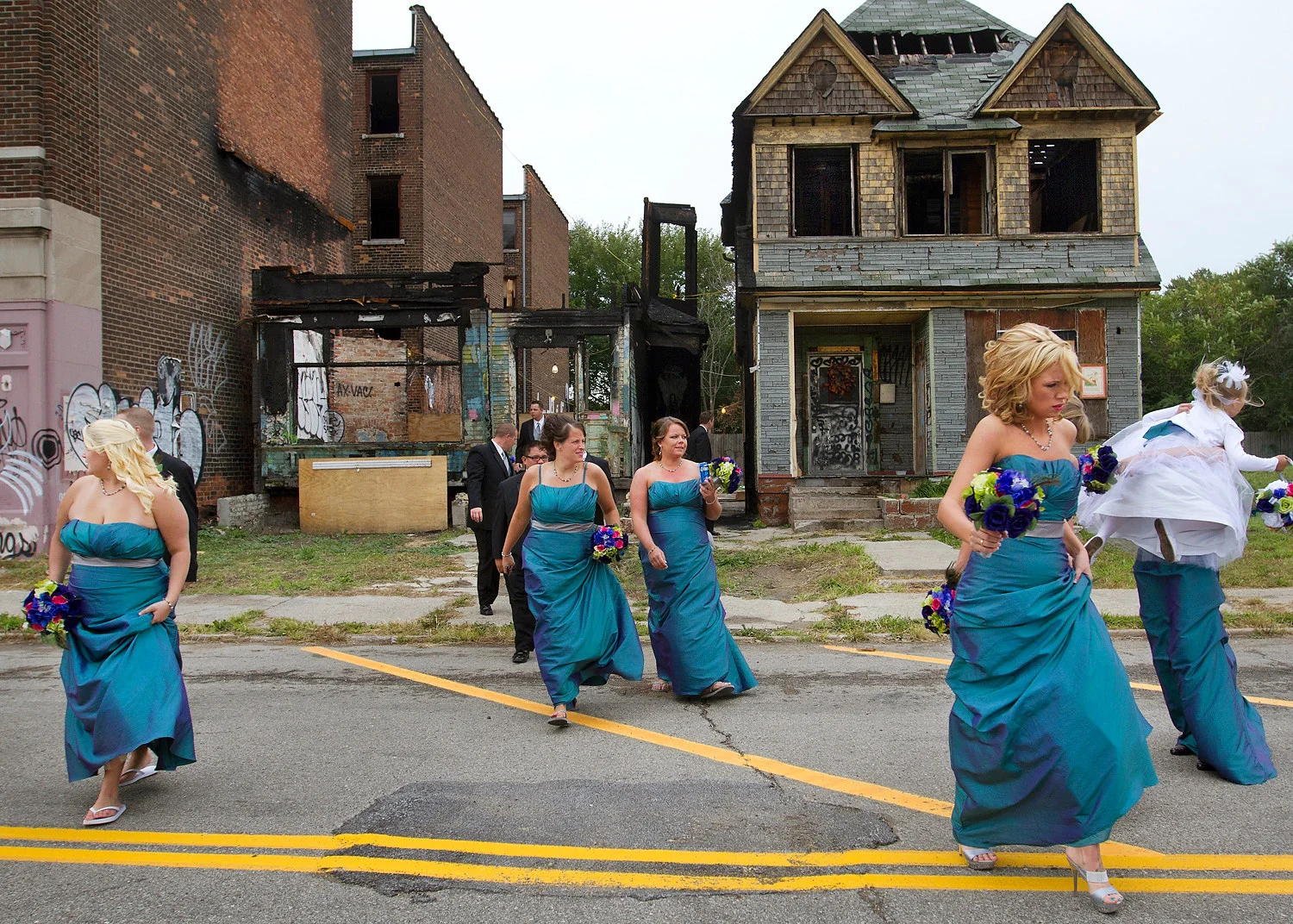  A bridal party walks across 14th Street between Dalzelle Street and Michigan Avenue after a photo shoot inside the burned house on the left in downtown Detroit across from the historical Michigan Central Train Station. The two houses were part of a 