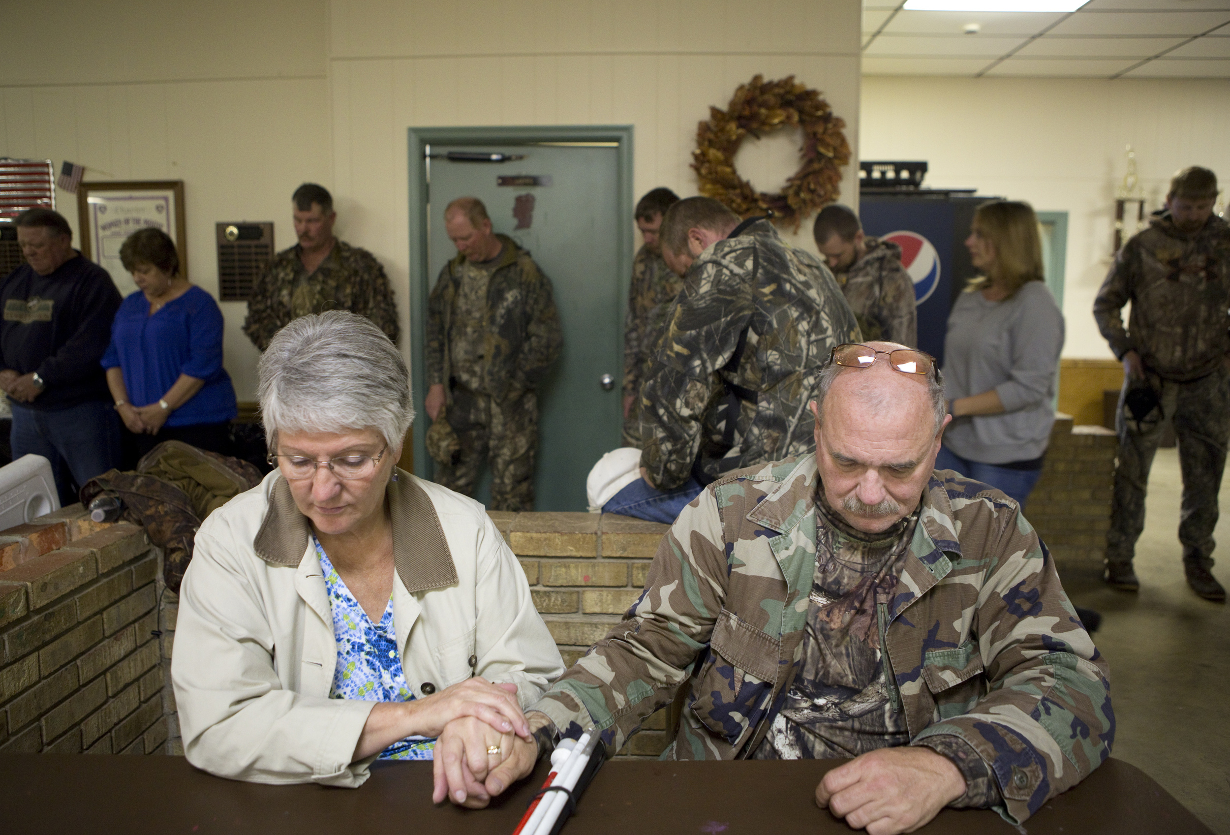 Terry Doyle, left, holds Mike's hands during prayer for the after-hunt meal. Hunters reconvened at the Moose Lodge in Bedford to fill their stomachs and also received awards and prizes for their efforts. The Doyles stayed at the Days Inn in Bedford the night before. Terry stayed behind at the hotel to catch up on a few more hours of sleep after driving Mike there.